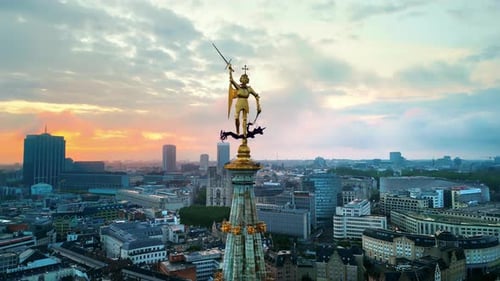 Aerial drone view of statue of Saint Michael atop the spire of the Brussels Town Hall at sunset in B