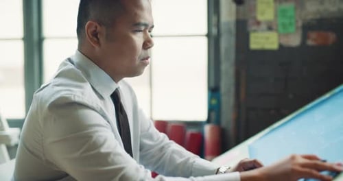 Man Working at an Architectural Drafting Table