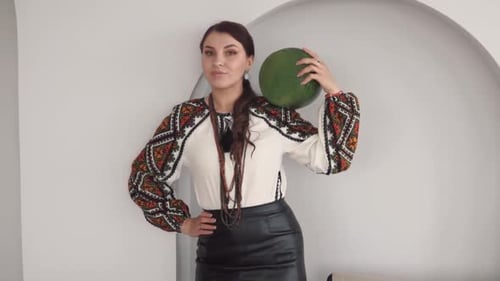 Woman Holding Round Green Object Indoors Posing