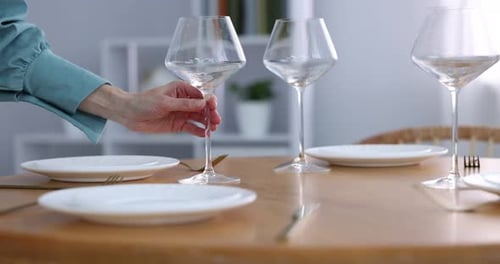 Woman setting table for dinner at home, closeup