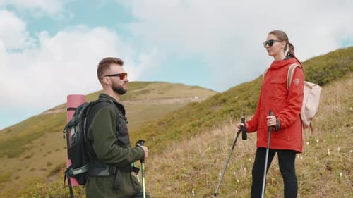 Travel in Mountain in Summer Vacation Portrait of Two Tourists with Sticks for Nordic Walk on Slope