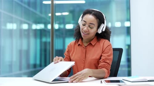 Woman Relaxing at Desk After Working on Laptop
