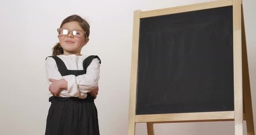 Smiling Girl Standing By Blank Chalkboard