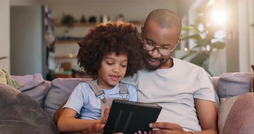 Vater, Kind und entspannen Sie sich mit dem Tablet auf dem Sofa zu Hause, um ein Online-E-Book zu lesen