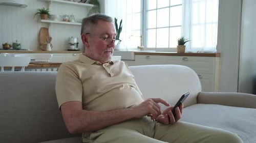 Man Using Mobile Phone on Couch at Home