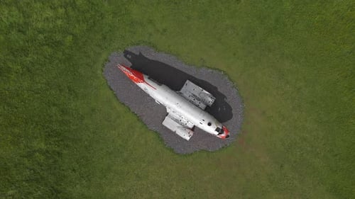 Aerial View of Abandoned Airplane on Gravel Amid Green Grass
