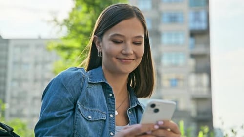 Young Woman Using Phone Outdoors in City