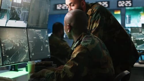 Soldiers Analyzing Data at Multiple Computer Monitors