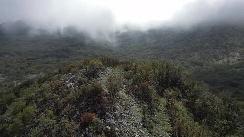 A Drone Flies Over a Mountain Peak and Reveals a View of the Mysterious Fog Shrouding the Majestic