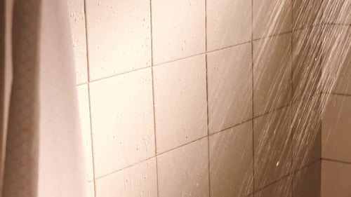 Water Running from Shower Head onto Tiles