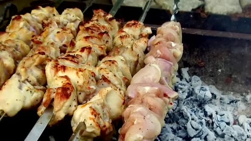 Cooking, Barbecue and Food Concept - Shashlik Meat Roasting on Skewers In