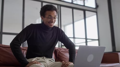 Man Talking on Laptop Video Call at Home
