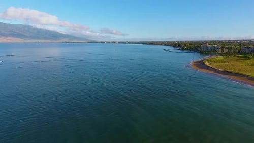 Calm clear water of shallow lagoon washing sandy beach in front of green garden surrounding holiday