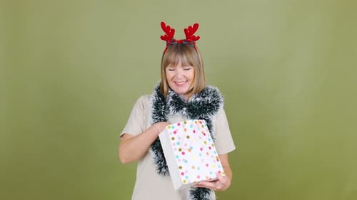 Woman With Gift and Reindeer Antlers Opens Present