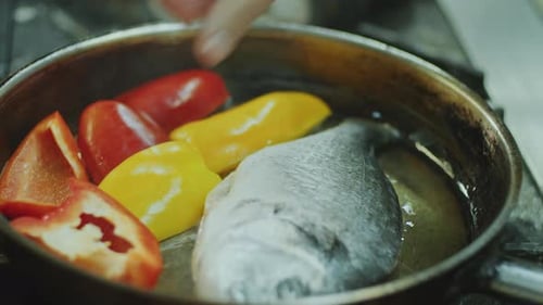 Fish and Bell Peppers Cooking in Skillet