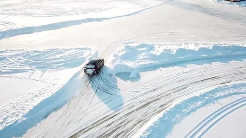 Black Car Drifting on Frozen Lake in Winter