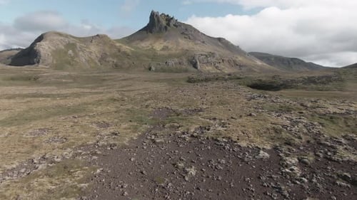 Flying above icelandic volcanic green lands, towards spectacular mount