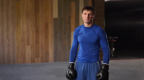 Man in Boxing Gloves Training in Gym