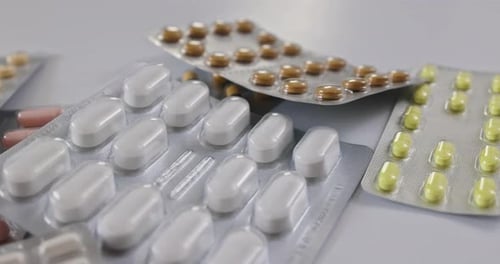 Colorful Pills in Blister Packs on White Surface