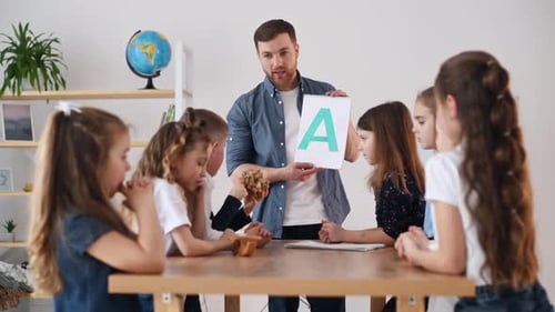 Learning A letter. Group of children students in class at school with teacher