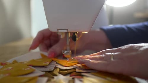 Erfahrene Hausfrau näht Quiltreste in einen Topflappen — isolierte ORANGE SCRAPS-SERIE