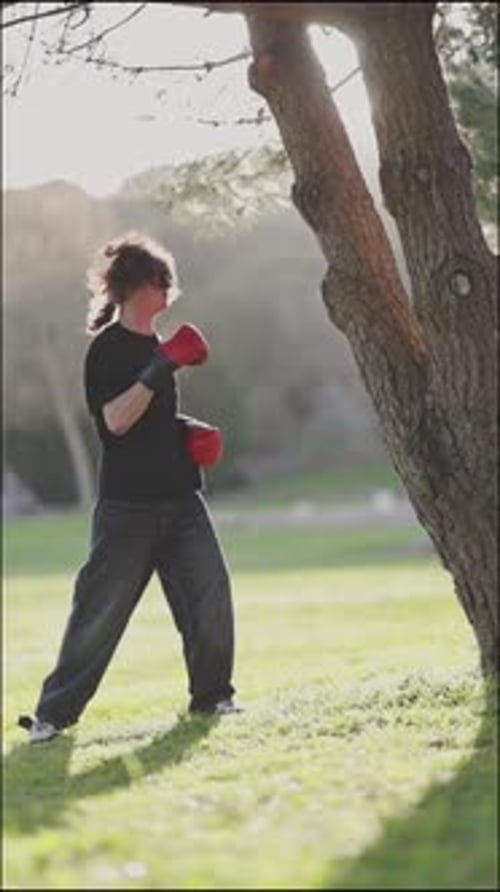 Young Adult Boxing Training Punching Tree in Park