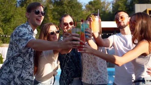Friends Toasting with Cocktails at Outdoor Pool Party