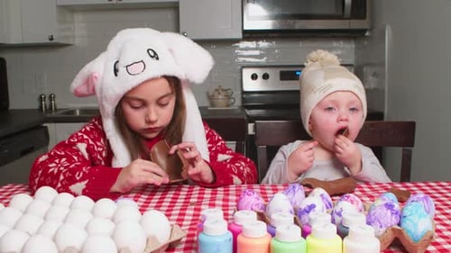 Little Boy and Girl Eat Easter Bunny at Home at Kitchen Table
