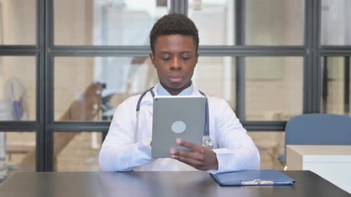 Young Adult Doctor Using Tablet in Office
