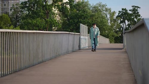Wide Shot Senior Man Walking in Slow Motion on Pedestrian Bridge Looking Around