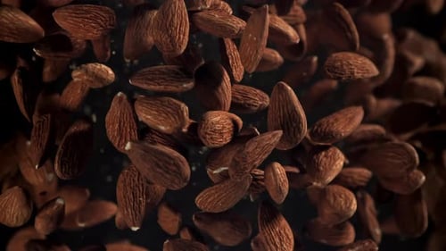 Falling Almonds in Slow Motion Against Black Background