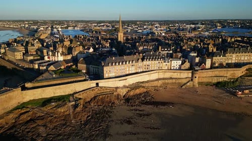 Outside of Saint Malo Intra Muros coastal shoreline during low tide at sunset, Saint-Malo, France. A