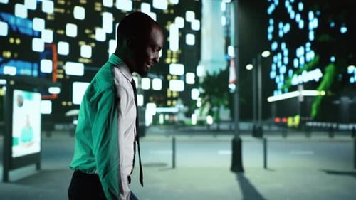 Young Adult Walking Down City Street at Night