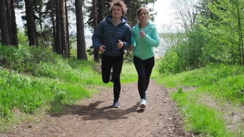 Sportive young people running. Couple run in the park during the day