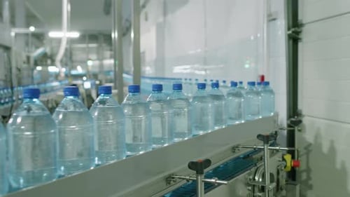 Conveyor Line Moving Plastic Water Bottles at Factory