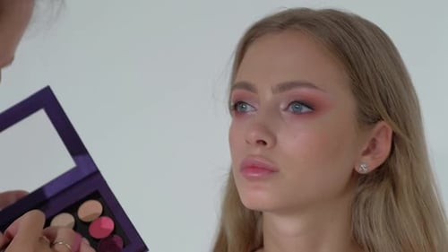 Blonde Model Getting Eye Shadow Applied by Makeup Artist