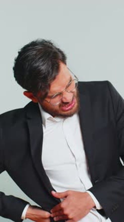 Man in Suit Clutching His Stomach in Pain