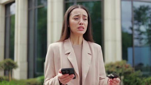 Worried Woman with Phone and Credit Card Outdoors