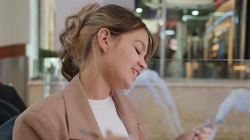 Cheerful Young Woman Shares Joyful Gesture Beside Mall Fountain Amusing Young Female