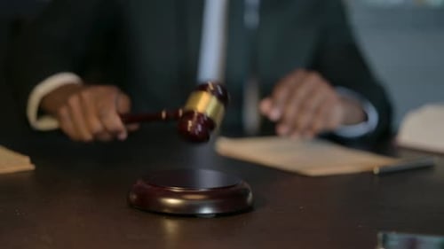 Primer plano de un juez africano golpeando el mazo y pronunciando la sentencia