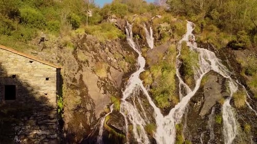 Waterfall Flowing Down The Mountain Cliff On A Sunny Day. - aerial ascend