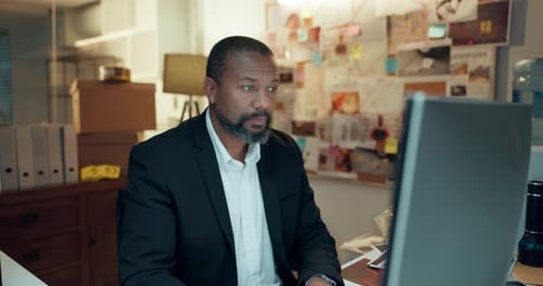Man At Computer In Office Environment