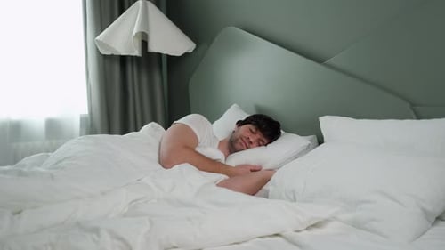 Man Sleeping Peacefully in Bed with Eye Mask