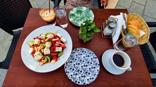 Slow motion close-up of lunch with Greek traditional salad recipe presented on plate dish meal on ta