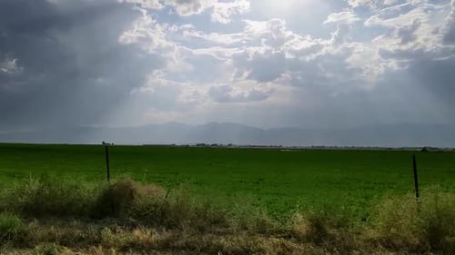 Driving View With Storm Clouds , Sun Beaming Down Through The Gaps The Cloud.