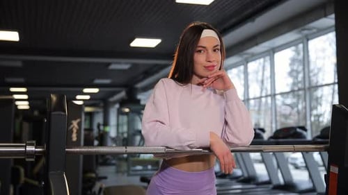 Woman in Gym Exercising on Treadmill Near Glass Window
