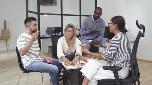 Multiracial Coworkers Eating Pizza in the Office