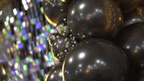 Black Balloons With Flowers and Glittery Backdrop