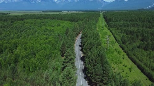 Blick von oben auf Autos, die auf der Autobahn fahren, umgeben von Wäldern und Bergen Irrl