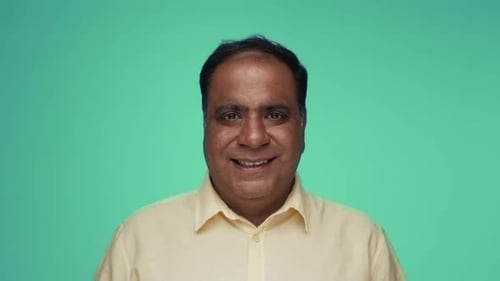 Smiling Man in Front of Teal Background